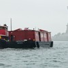 The tugboat Pegasus and the Lehigh Barge no. 79 passing the Statue of Liberty in the rain.